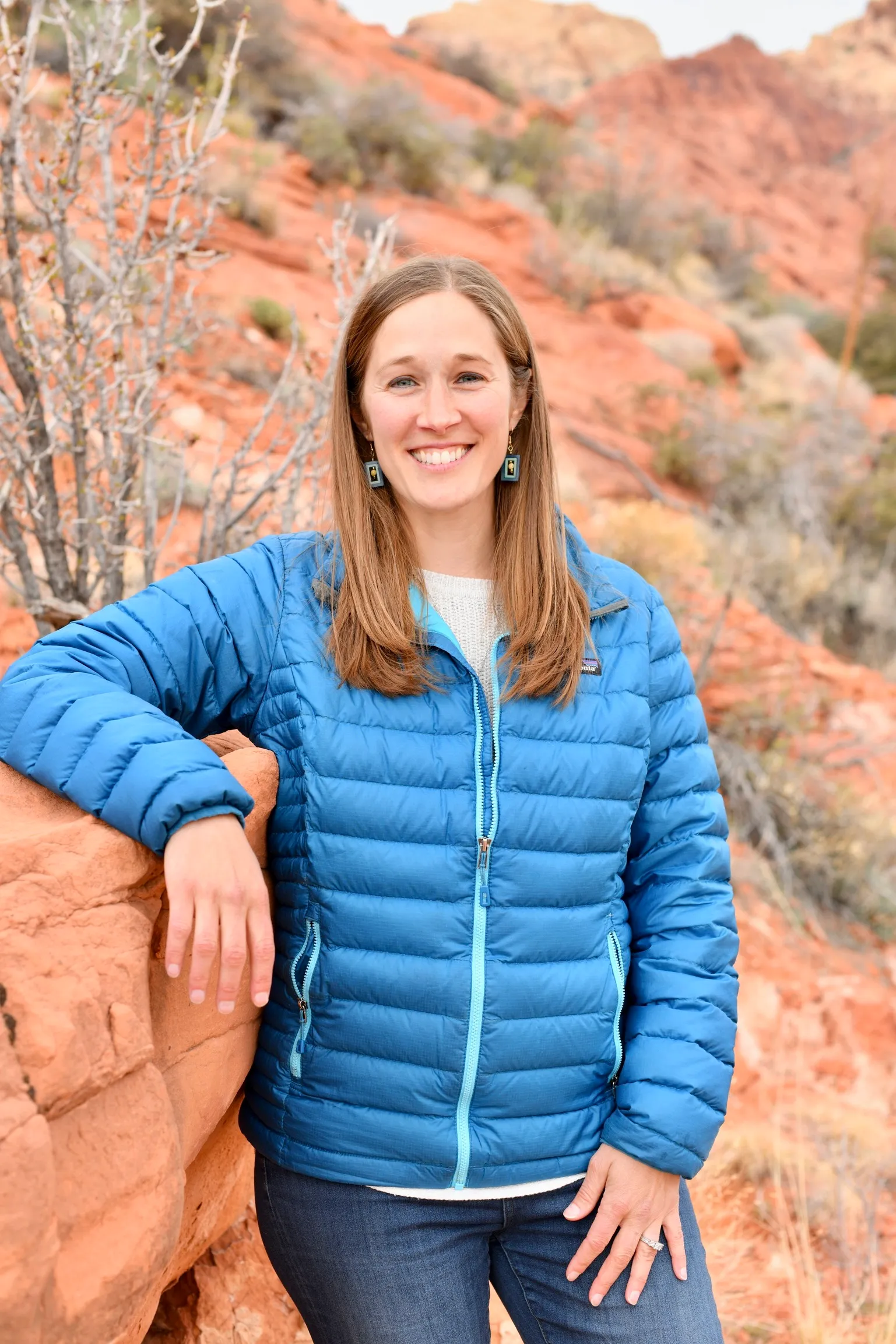 Adrienne, founder of Greener Path, smiling outdoors against red rock